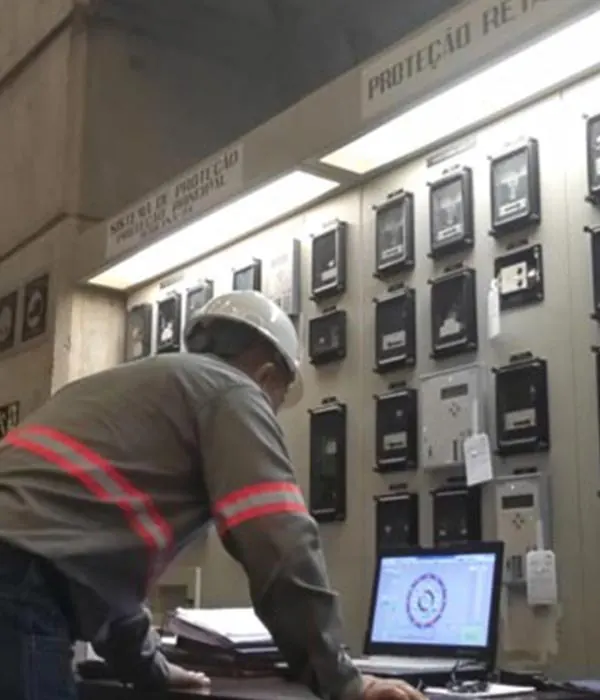 Técnico realizando ensaio elétrico em painel de proteção